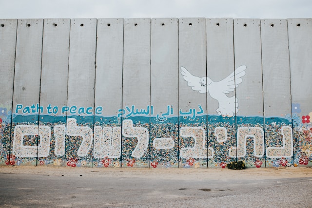 Grafitti do "Camiño á Paz" feito sobre o muro de Netiv HaAsara preto do boder con Gaza. Unha pomba branca sobrevoa a mensaxe escrita en inglés "Path to Peace" que tamén aparece en hebreo e árabe.